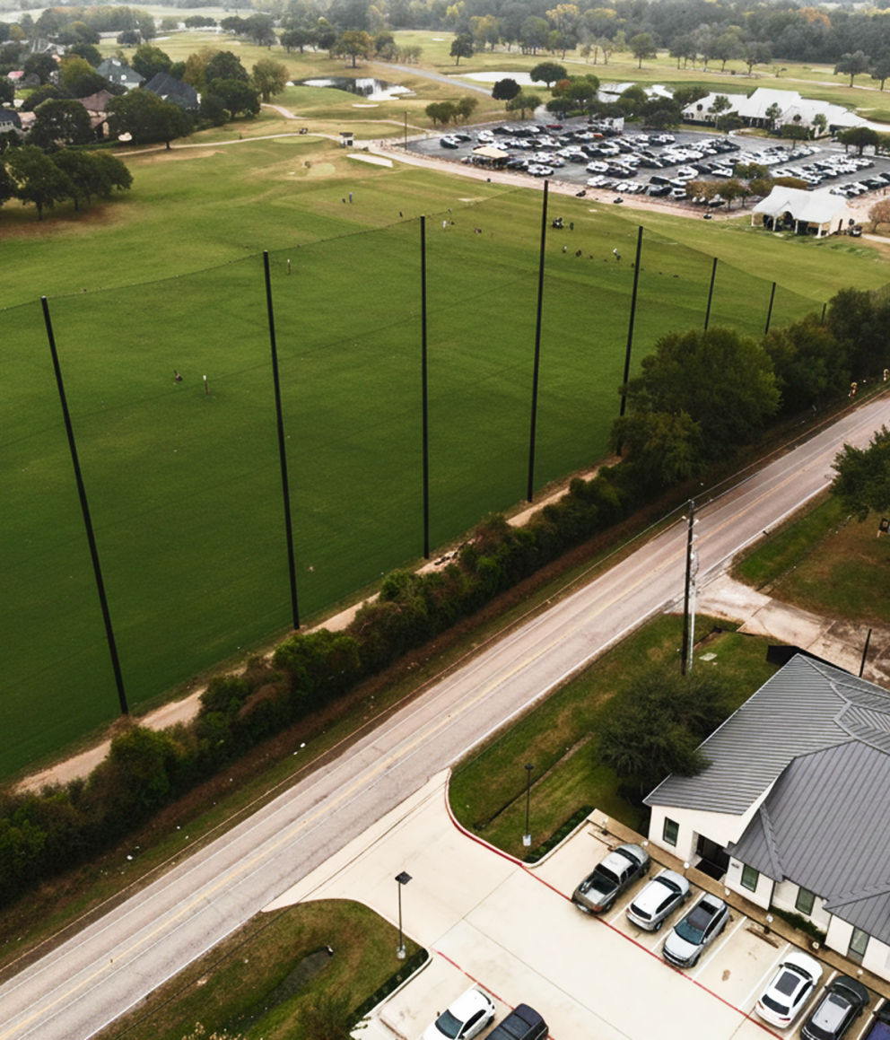 “Aerial view of custom golf course netting at BlackHorse Golf & Country Club, showing the driving range, golfers practicing, and parking area.